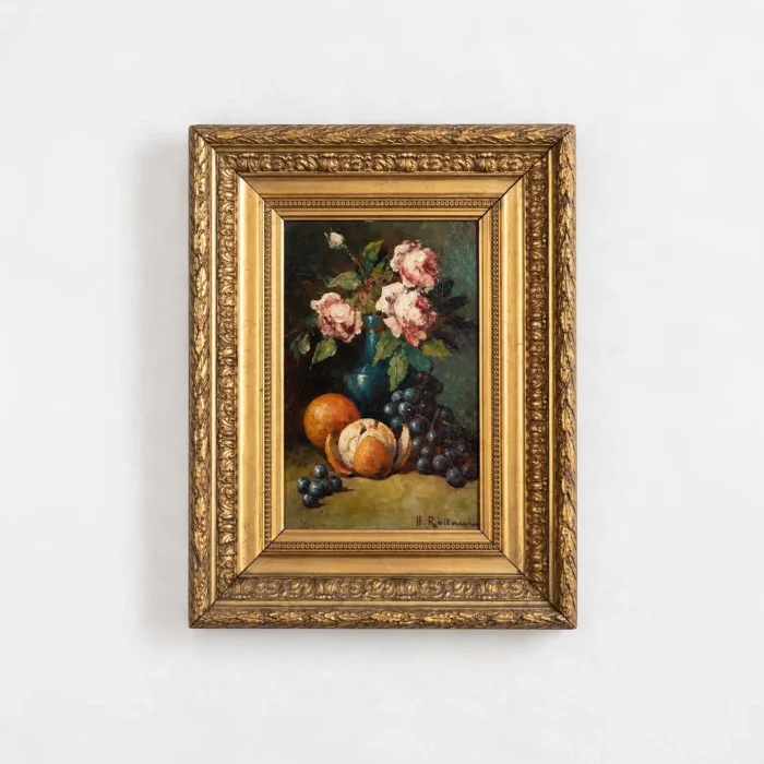 Antique French oil painting on panel depicting pink roses and ripe fruit, including oranges and grapes, in an ornate gilded frame against a white background.